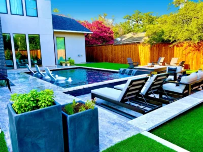Contemporary pool and patio design with lounge seating, porcelain pavers, and turf installation in a Dallas, Texas backyard